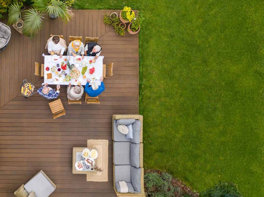 An aerial view of a family enjoying their new deck built by United Land & Snow Management