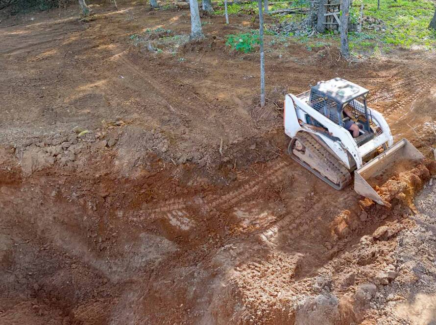 An earth moving machine is land leveling and grading a property in New Jersey